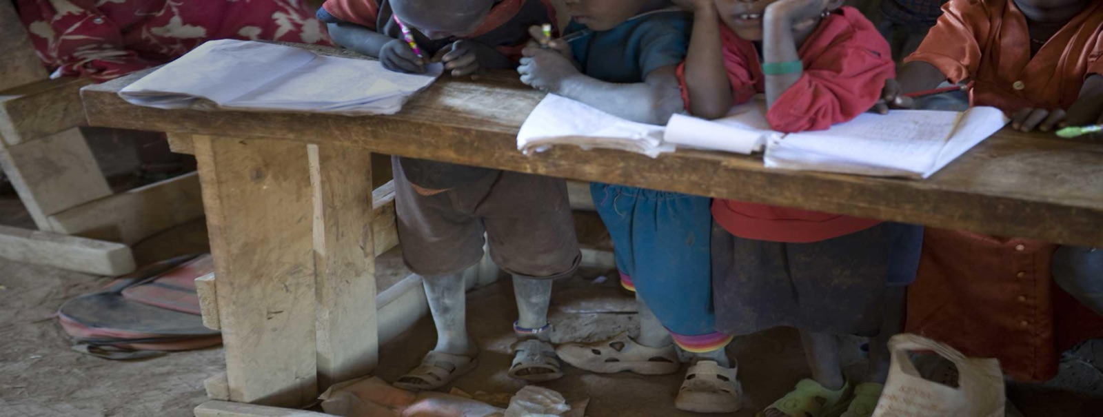 Schoolchildren write at a wooden desk